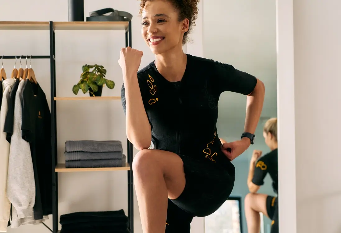 Afvallen met EMS - Intensieve indoor workout voor vetverlies Een vrouw in een EMS-pak doet een intensieve indoor workout met EMS-training voor effectief afvallen en vetverbranding.