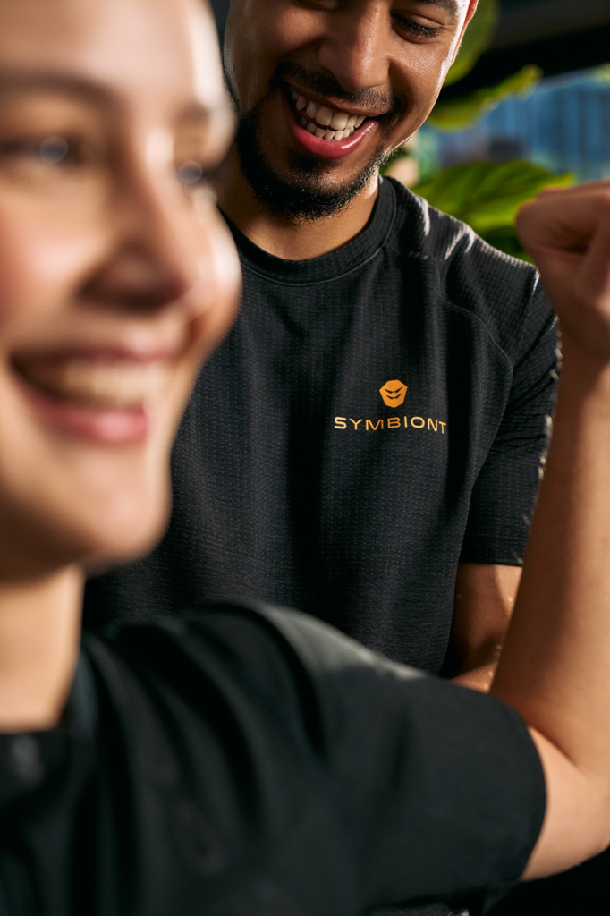 Nahaufnahme eines Kunden und eines Personal Trainers bei der Besprechung von Fitness- und Trainingszielen in einem lokalen EMS-Studio für das beste SYMBIONT-Trainingserlebnis.